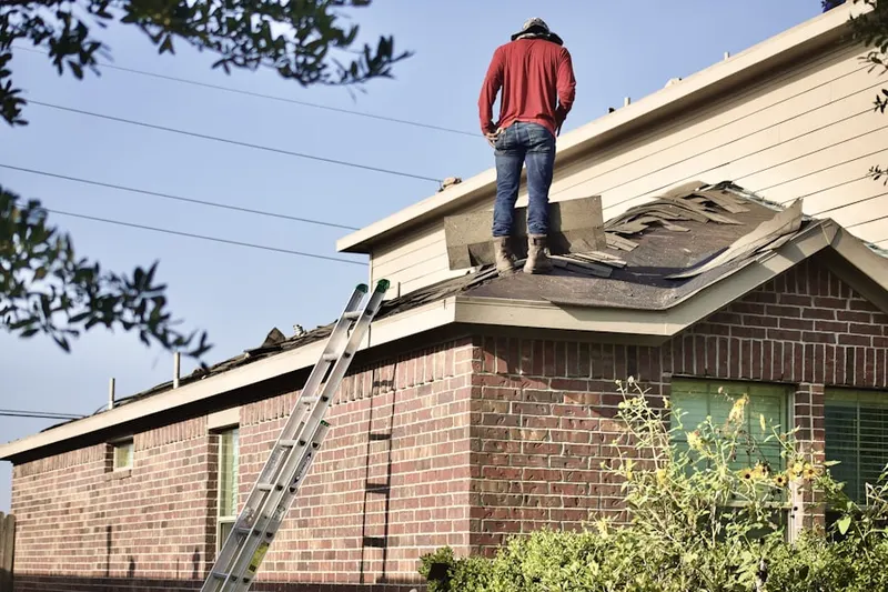 Professional roofer working on a residential roof in Mill Pond